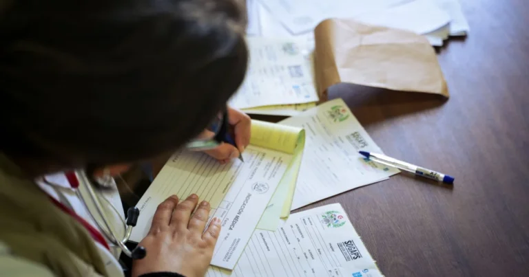Doctor filling out medical records