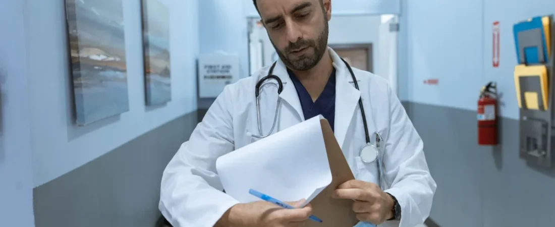 Doctor reviewing a patient chart in a hospital hallway