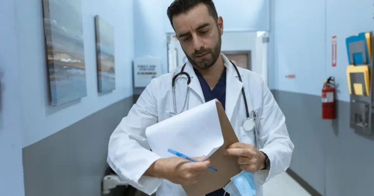Doctor reviewing a patient chart in a hospital hallway