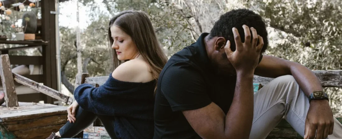 Couple sitting back to back outdoors during a separation