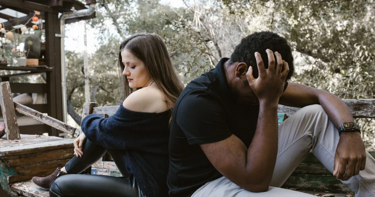 Couple sitting back to back outdoors during a separation