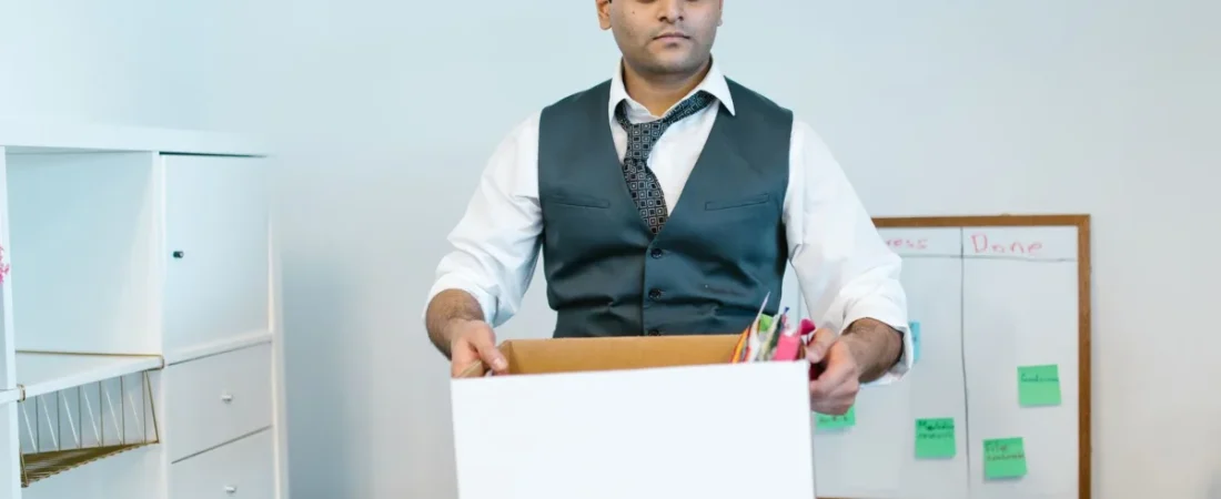 Employee packing office belongings into a box after leaving a job