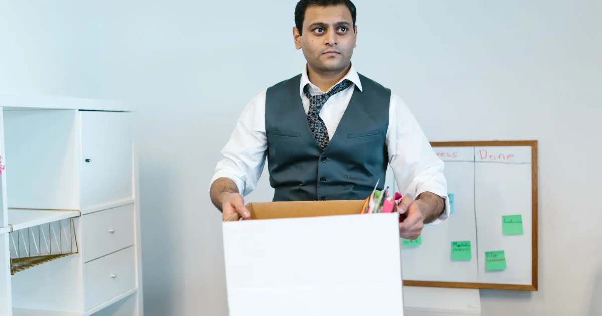 Employee packing office belongings into a box after leaving a job